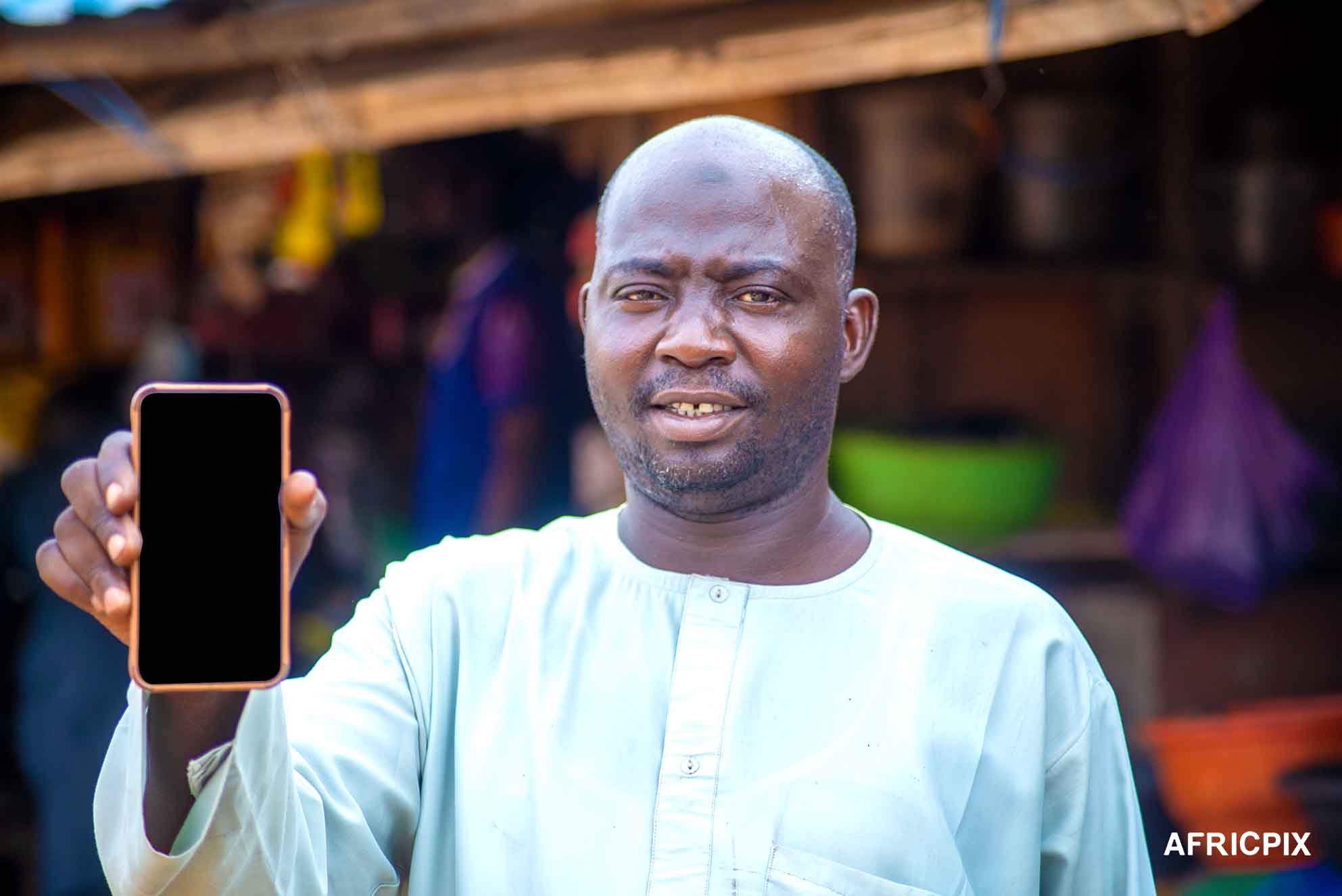 Nigeria Market Man In Front of Shop Holding A Phone