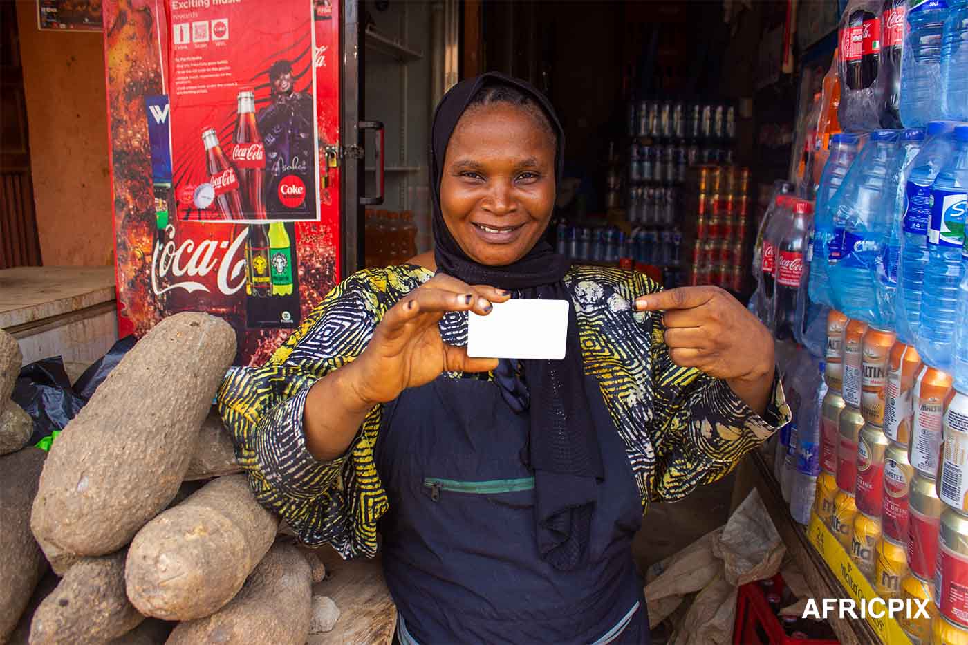 Nigeria Market Woman In Front of Shop Holding Credit Card