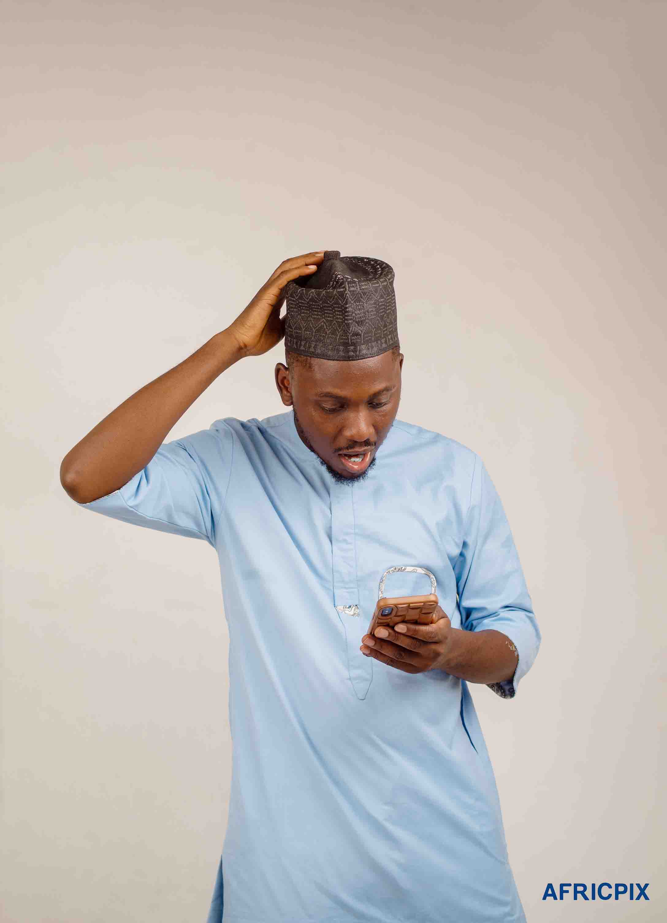 Surprise Nigeria Hausa Man Hand On Head Looking At Phone